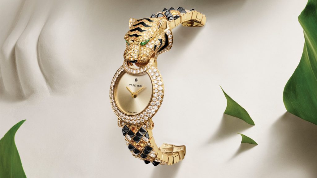 MIRADA FELINA Este Reloj Joya Tigre se declina en caja de oro amarillo y tiene a las espinelas negras, granates espesartinas, zafiros amarillos y naranjas como perfectos compañeros de diamantes talla brillante (3,3 quilates. La figura se completa con ojos de esmeralda talla pera, hocico de laca. La esfera, por su parte, es dorada rayos de sol,