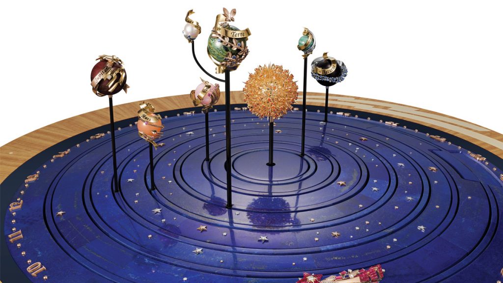bóveda celeste a ras de suelo
Sugiriendo la profundidad del cosmos, 15 discos de lapislázuli incrustados con estrellas en oro rosa y blanco y diamantes se suceden de manera concéntrica dentro de la esfera. Los planetas y la estrella fugaz se mueven a su propio ritmo en un entorno centelleante. Todo ello suscita una doble emoción, entre la inmersión en el universo y la belleza del trabajo joyero.